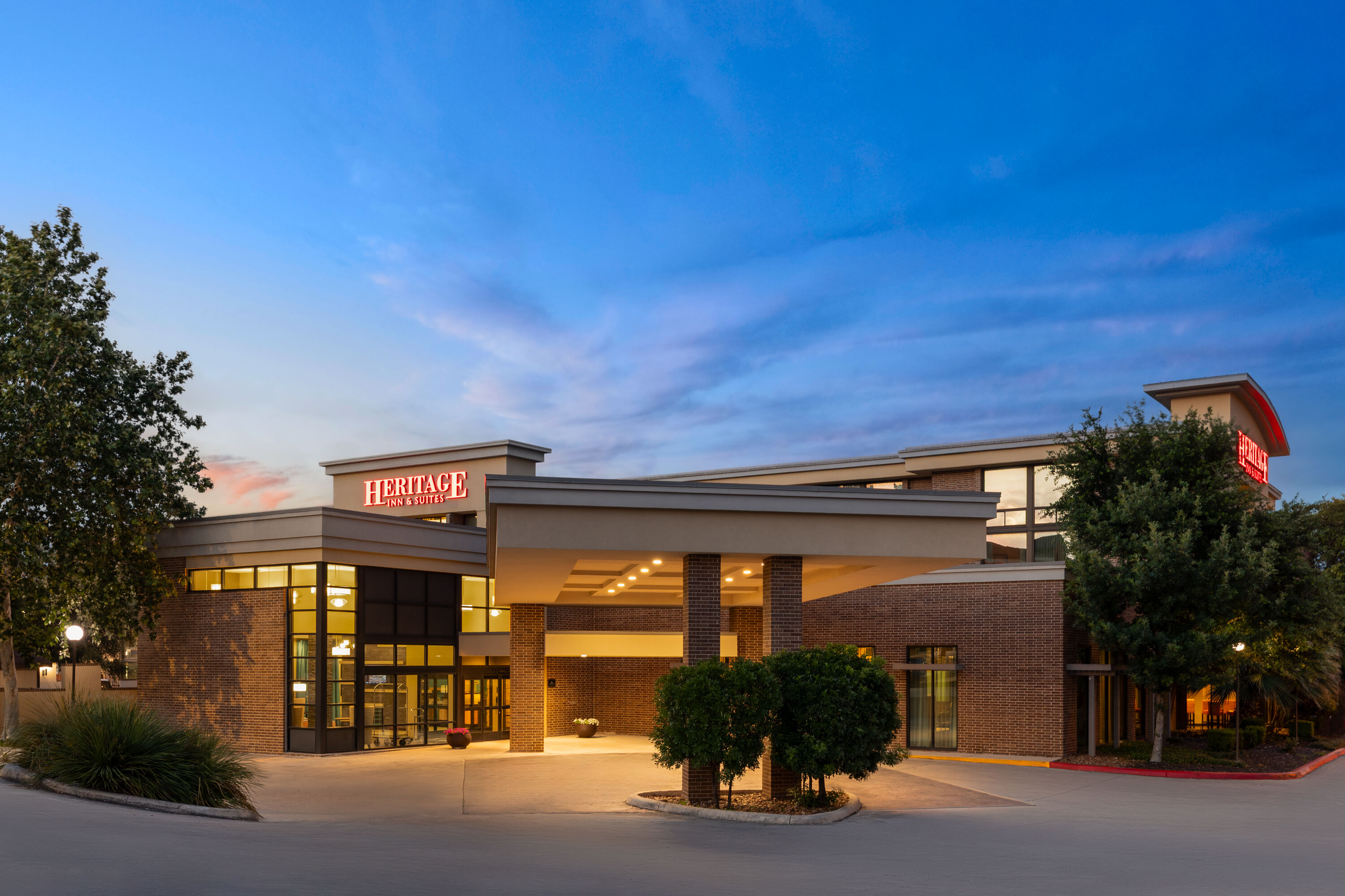 Exterior Dusk Image of Heritage Inn & Suites San Antonio Airport, Trademark Wyndham hotel in San Antonio, Texas