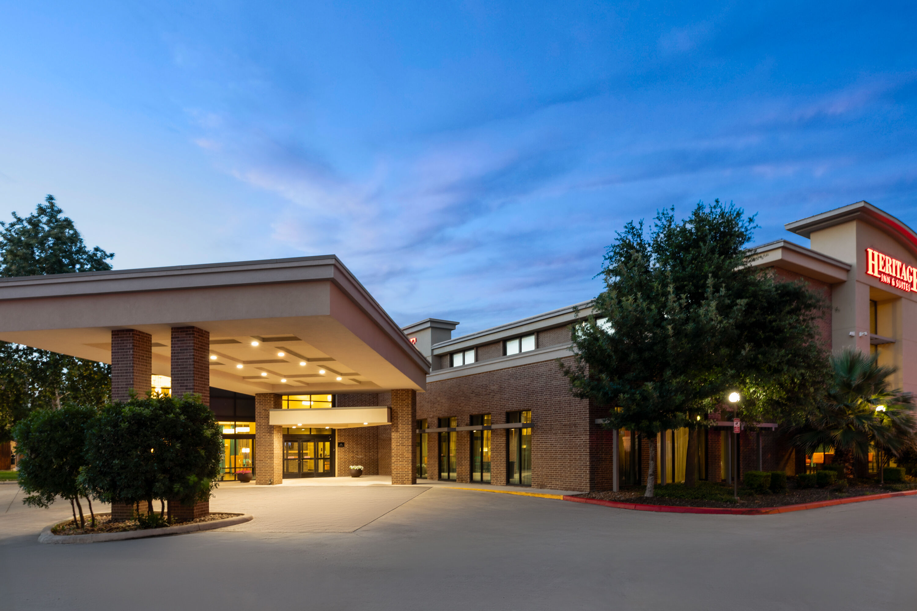 Exterior Dusk Image of Heritage Inn & Suites San Antonio Airport, Trademark Wyndham hotel in San Antonio, Texas